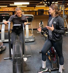 Ioana Gheta, préparatrice physique de l'INS Québec, guide une artiste du Cirque du Soleil à vélo stationnaire.