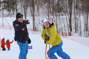 Claudel qui parle avec une athlète sur la piste de ski.
