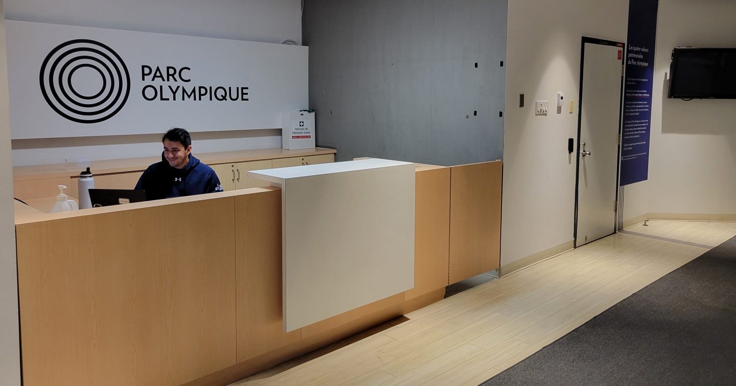 Un agent d'accueil souriant à l'entrée des bureaux relocalisés de l'INS Québec.